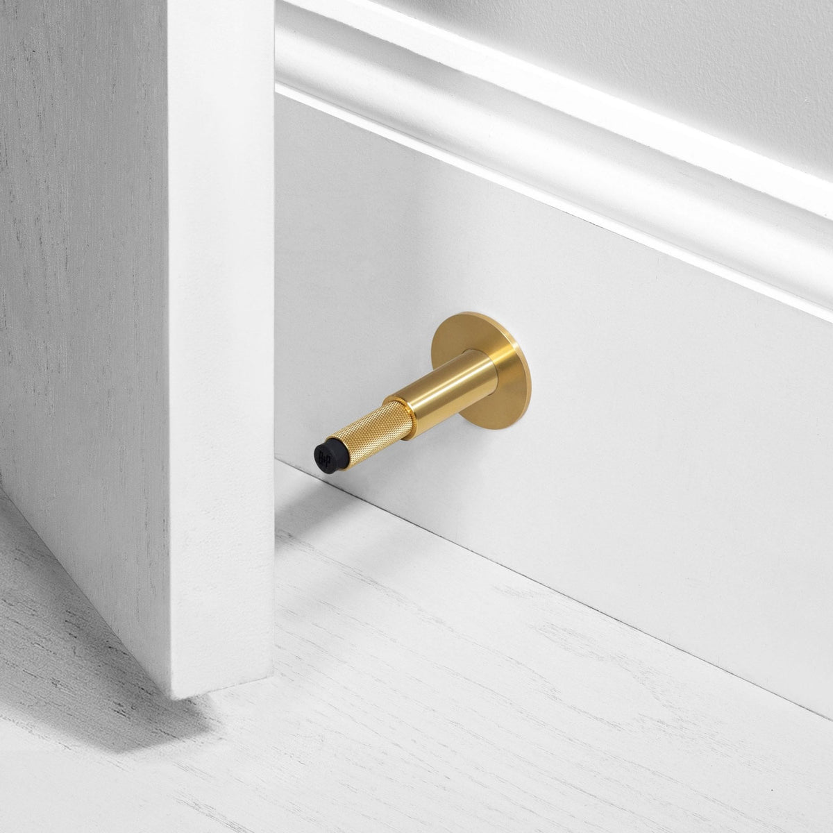 Cross Cut Knurled Wall Mounted Door Stop in Brass