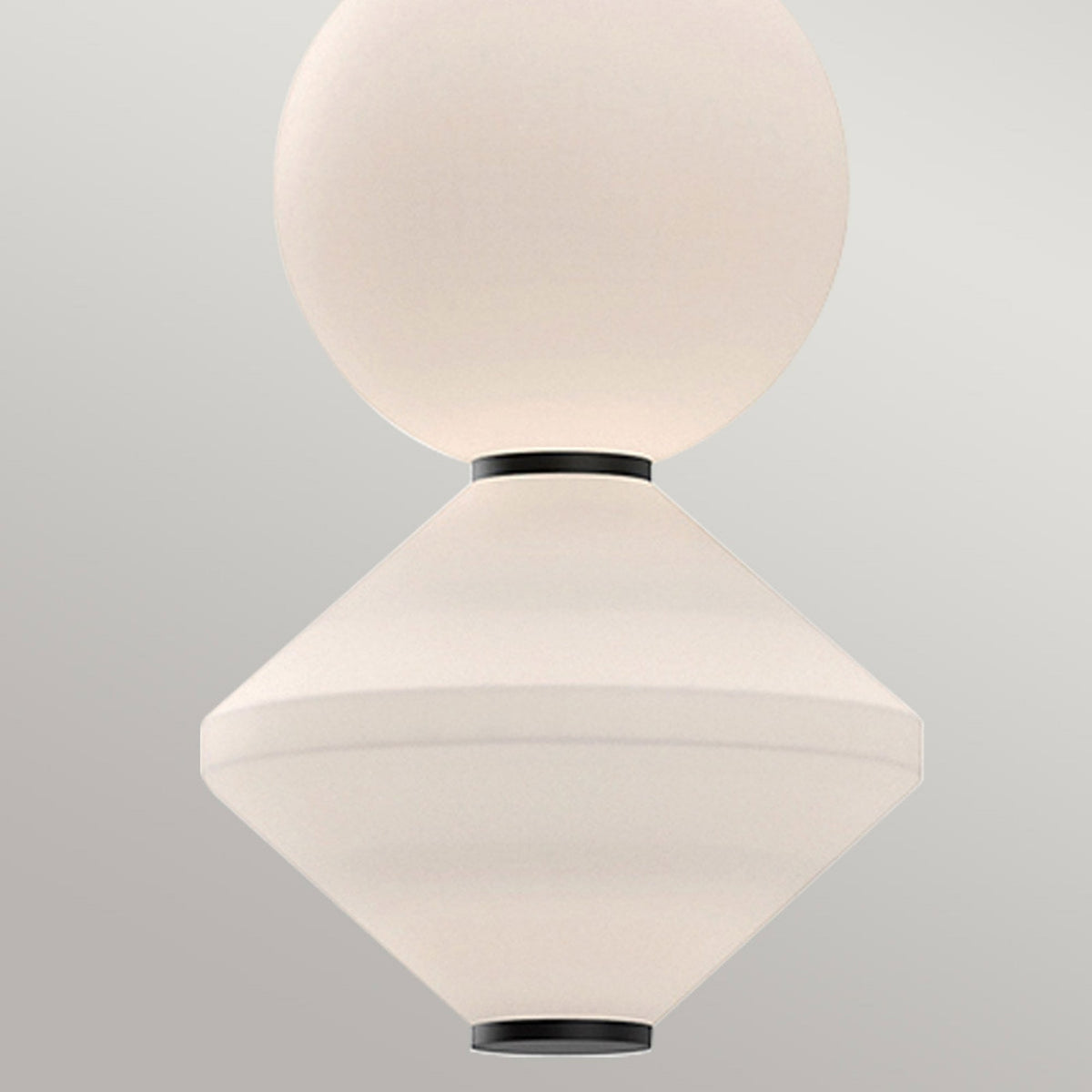 Close-up of the pendant light's spherical and conical white glass shades with black accents.