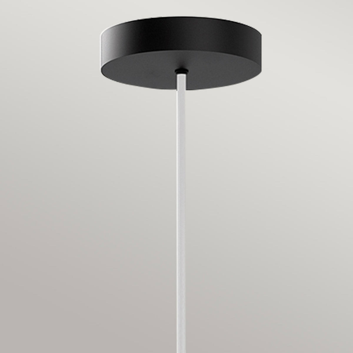 The sleek black ceiling rose and white cable of the pendant light.