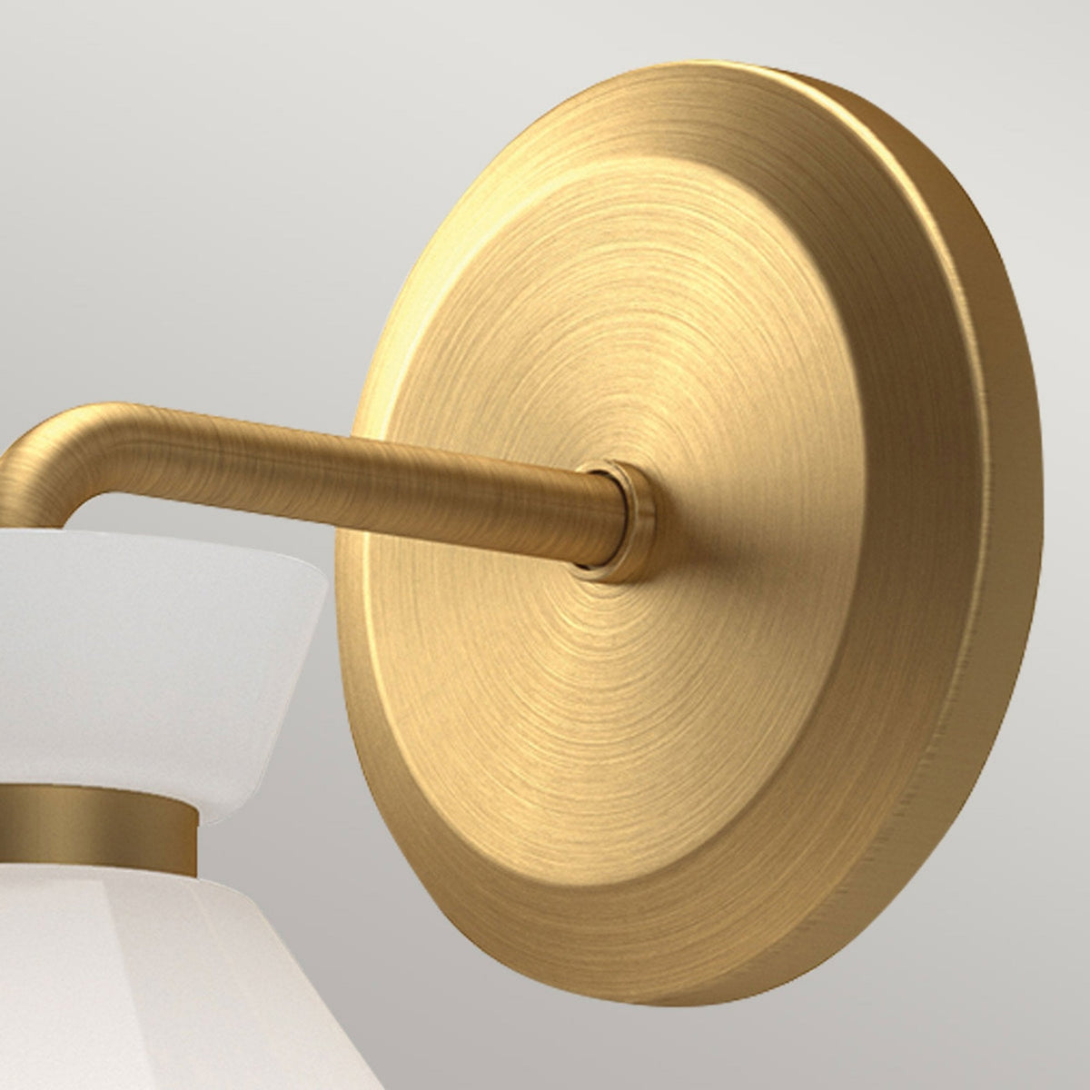 Close-up of the brass wall plate and arm of the wall light.