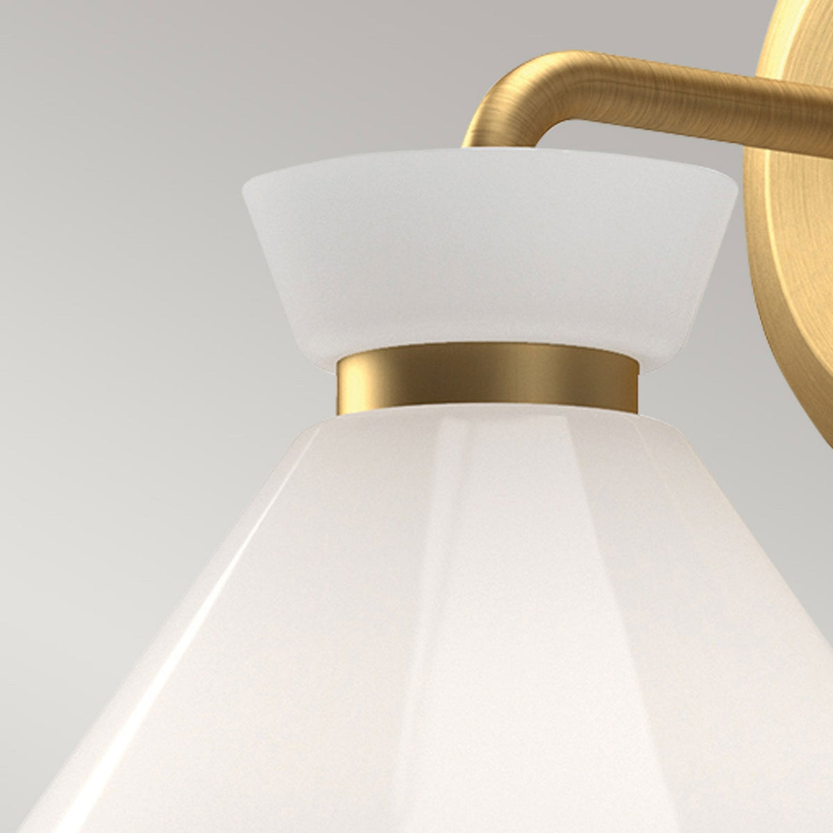 Close-up of the white conical shade and brass details of the wall light.