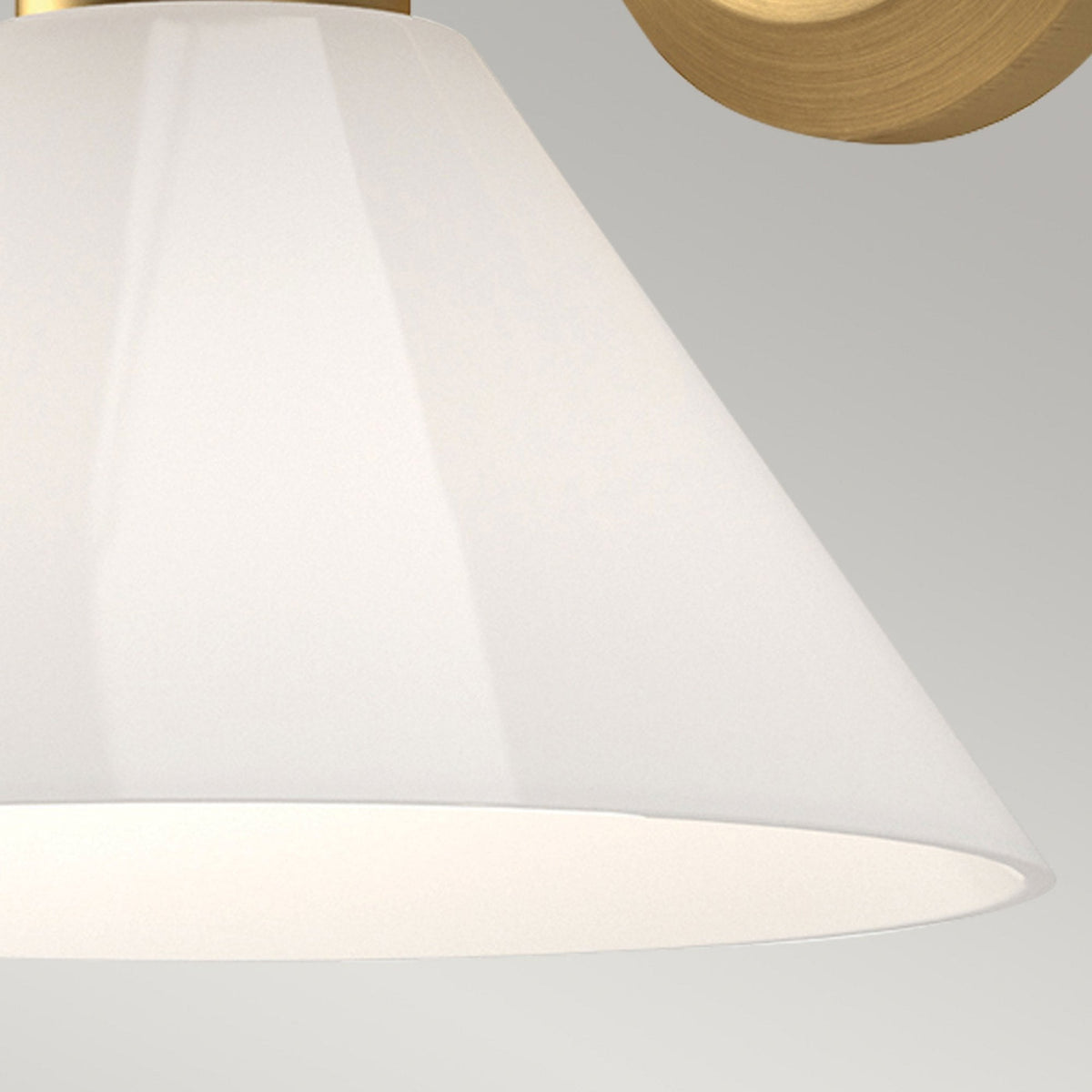 Close-up of the translucent white conical shade of the wall light.