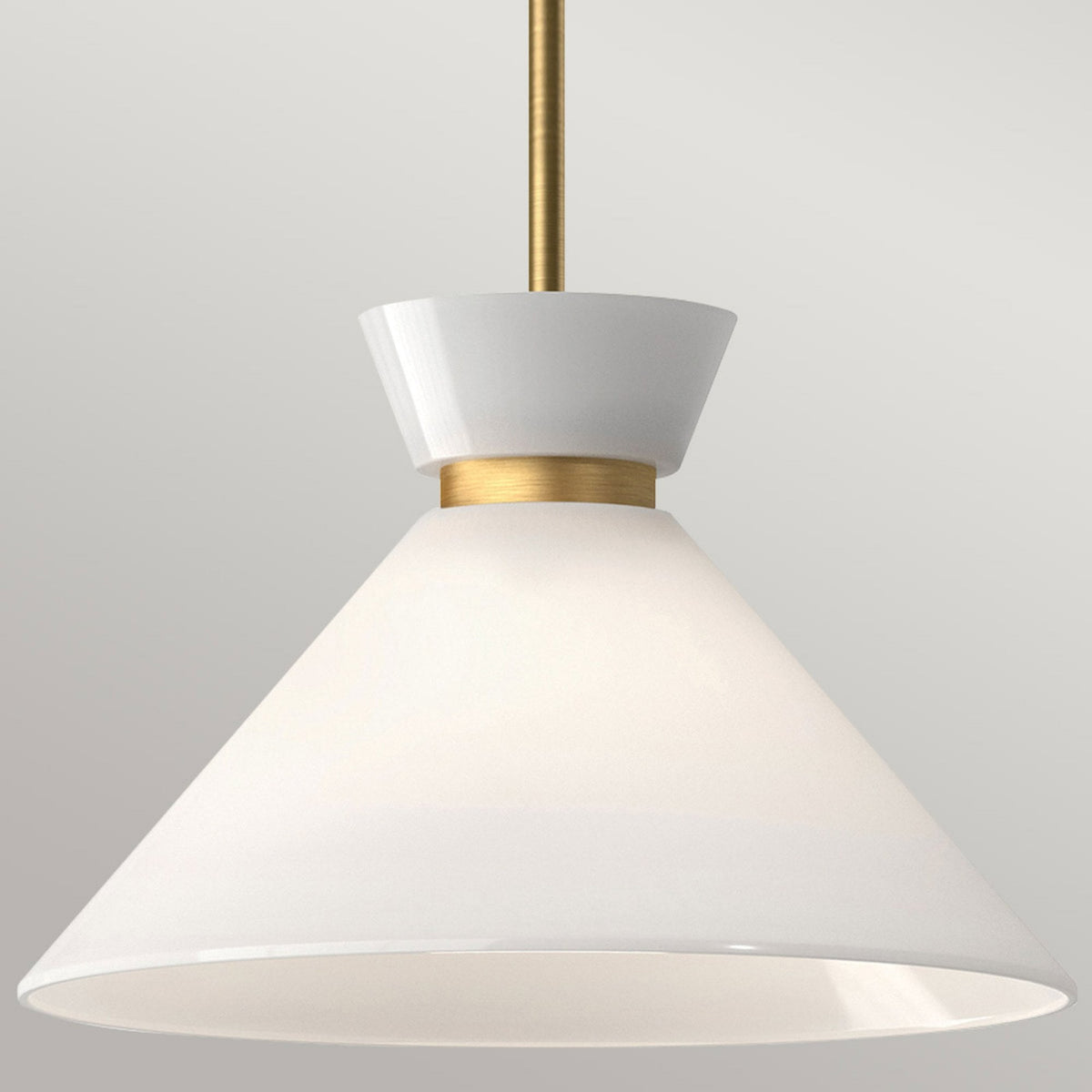 Detailed view of the white cone shade and brass fitting of a pendant light.