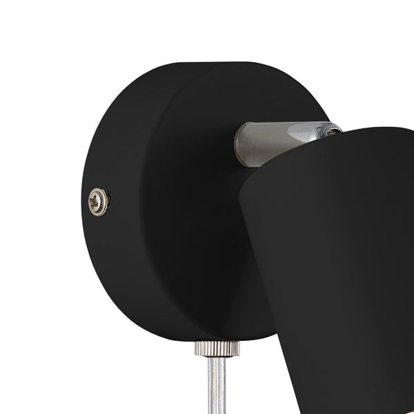 Close-up of the black, round base of a wall-mounted spotlight, showing a silver screw.