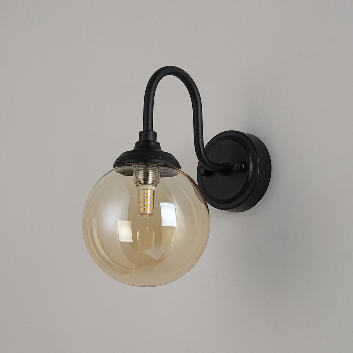 Loughton IP44 Curved Arm Wall Light in Satin Black with Smooth Round Glass Amber Diffuser