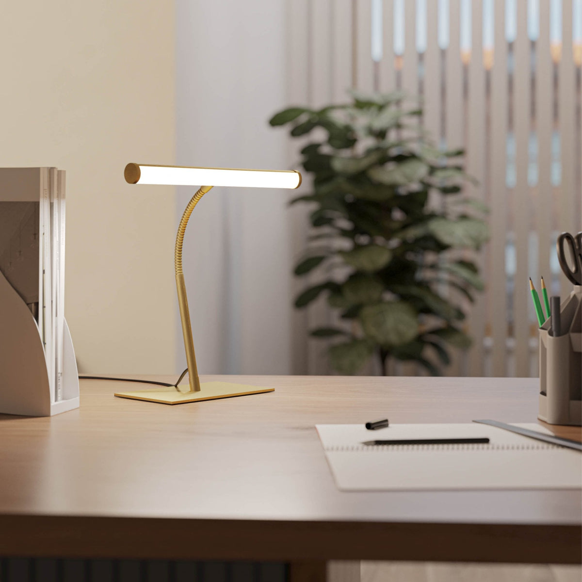 Gold desk lamp with a flexible neck and rectangular light on a wooden desk