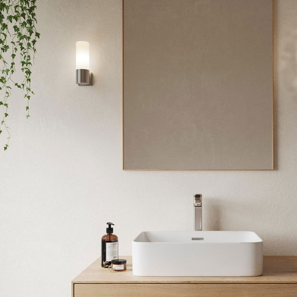 Contemporary bathroom with a sleek basin, chrome tap, and illuminated wall light.