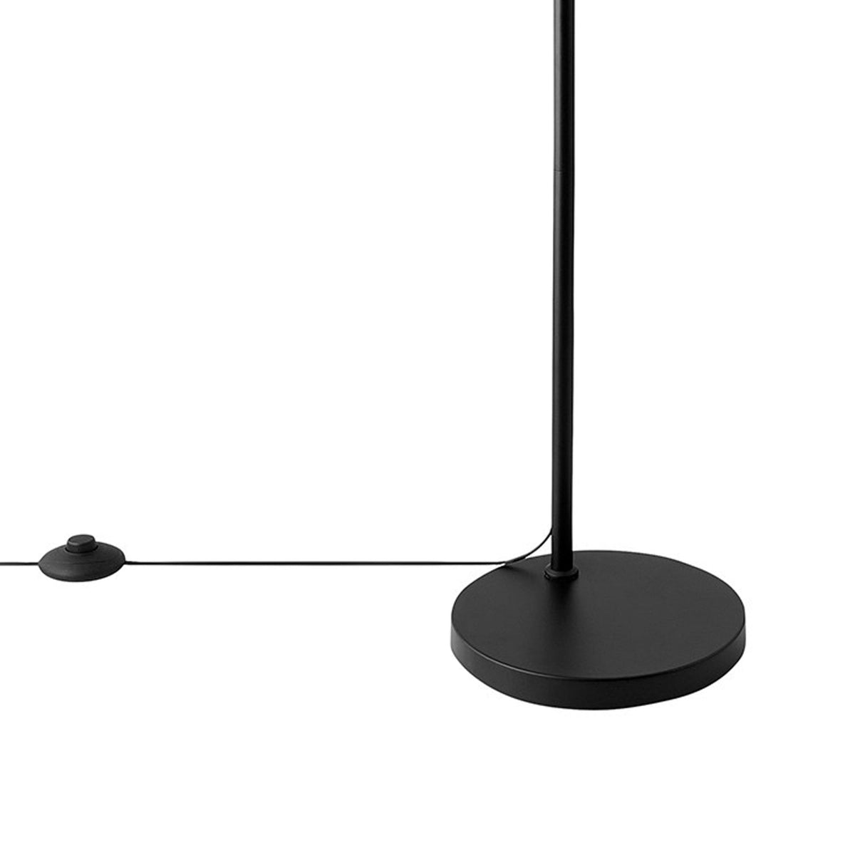 The round black base of the floor lamp and its cord with a foot switch.