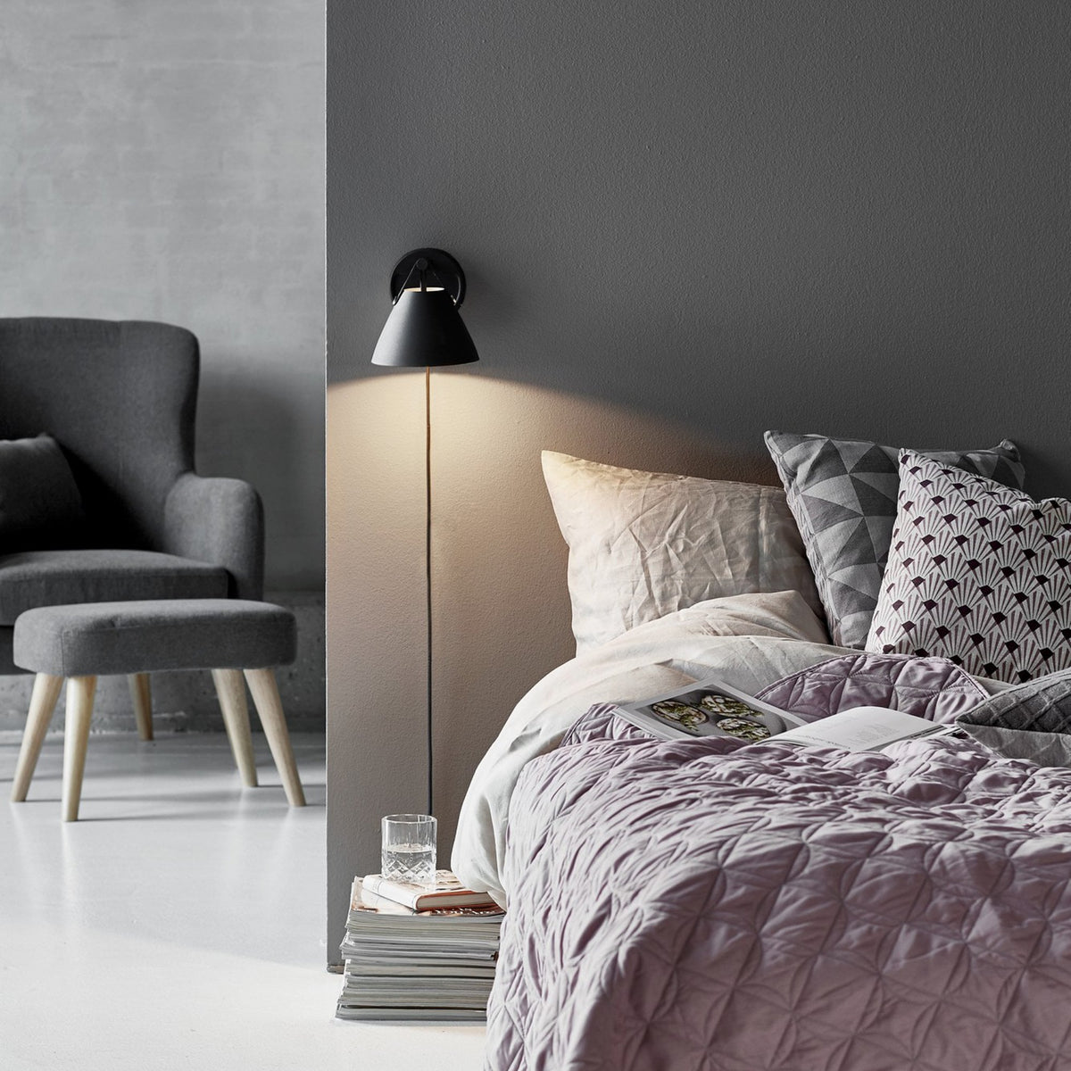 DFTP By Nordlux Strap 15 Adjustable Plugged Wall Light in Black with Leather Detail illuminates a bedroom