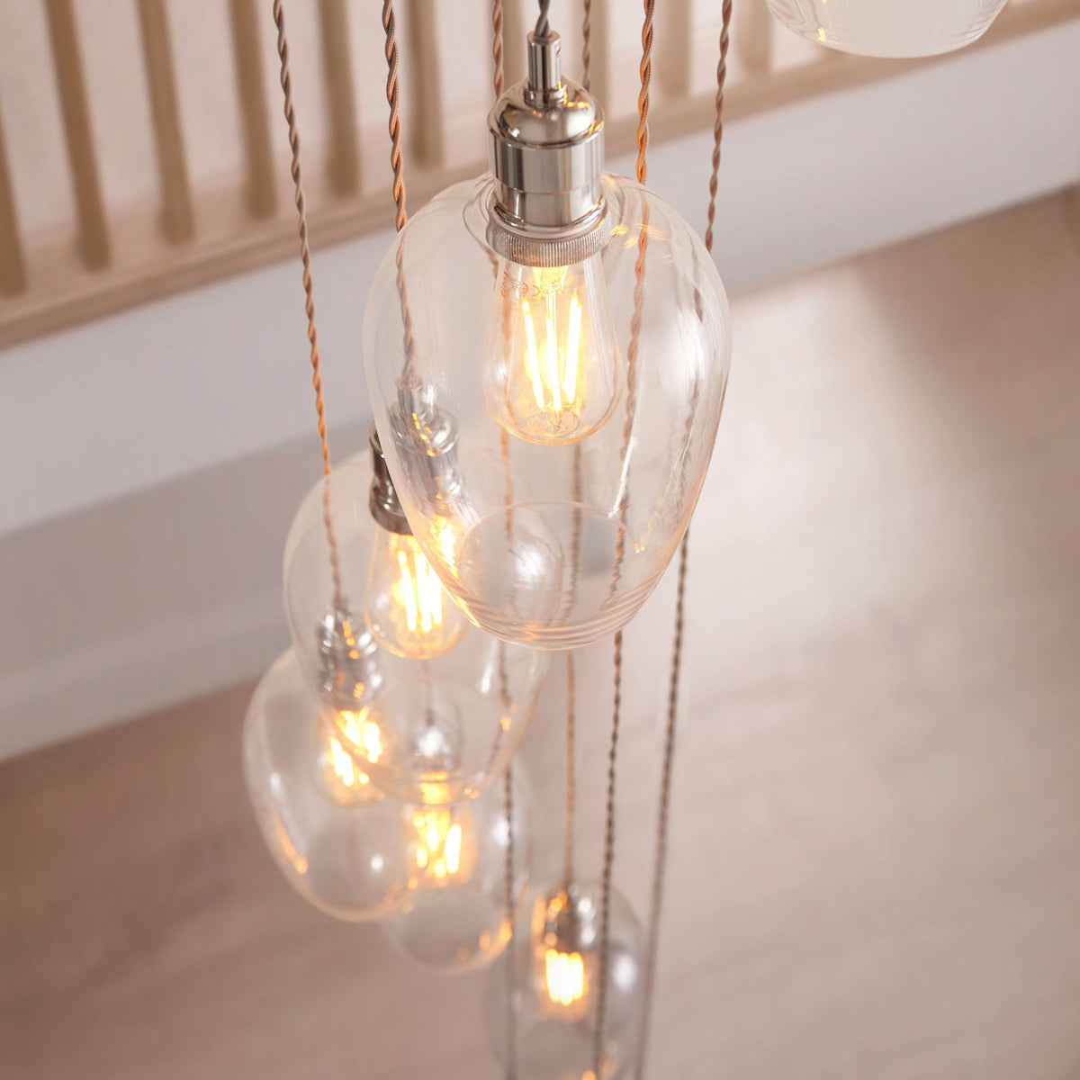 Close-up of the multi-pendant light fixture, showing individual clear teardrop shades with exposed filament bulbs.