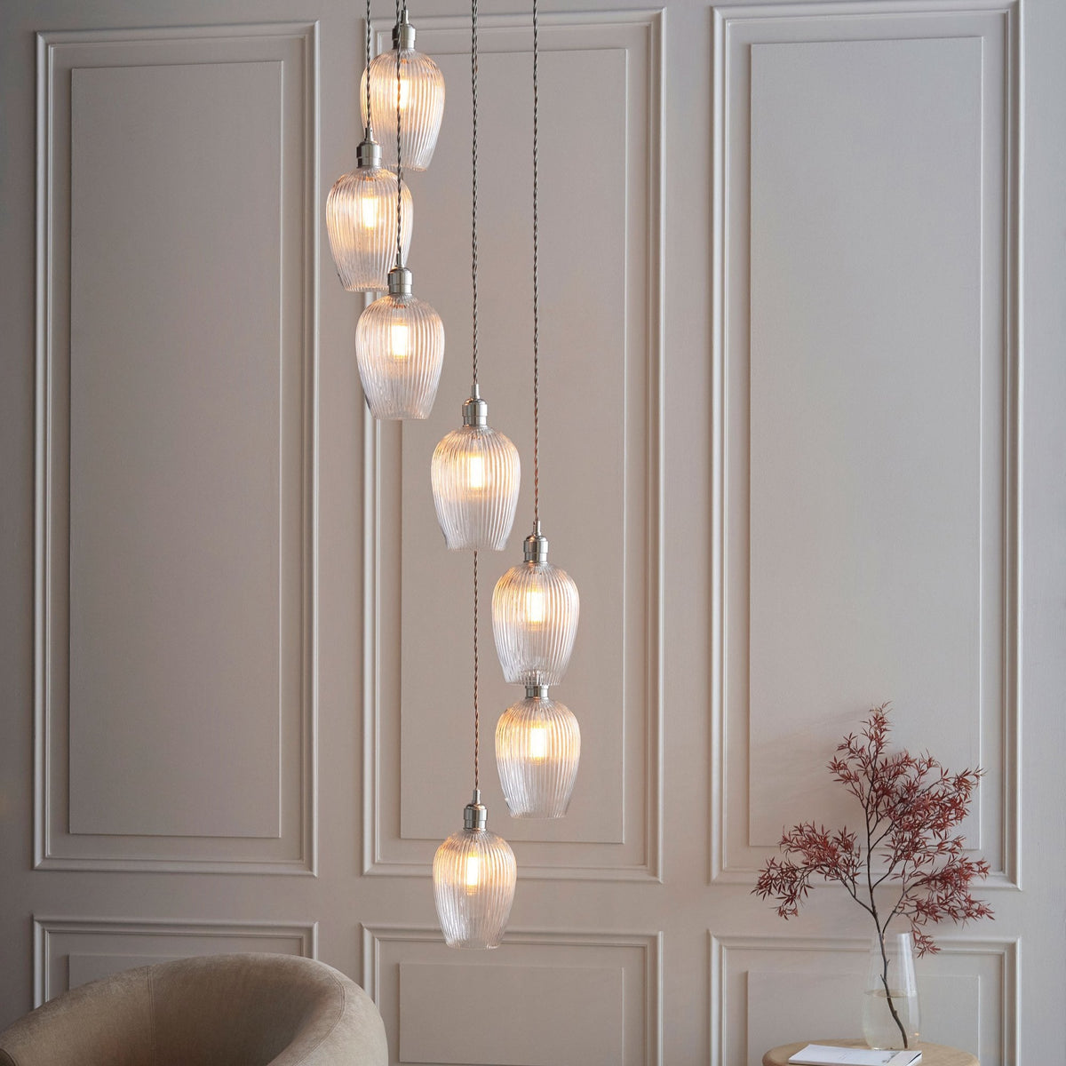 A cluster of glass pendant lights descending from the ceiling, adding a warm glow to a modern living area.