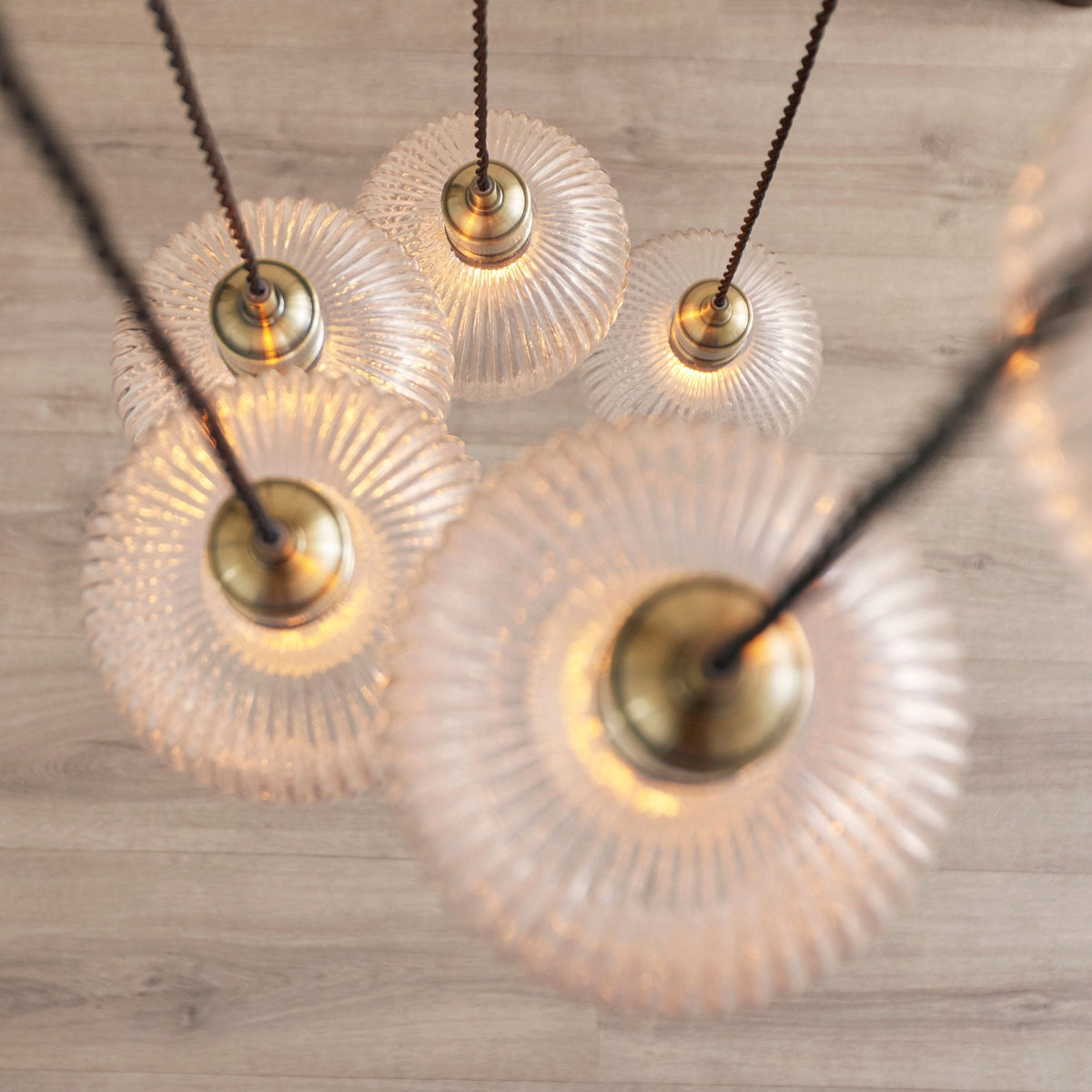 An overhead view looking down on the cluster of ribbed glass pendant lights, showcasing their circular top view.