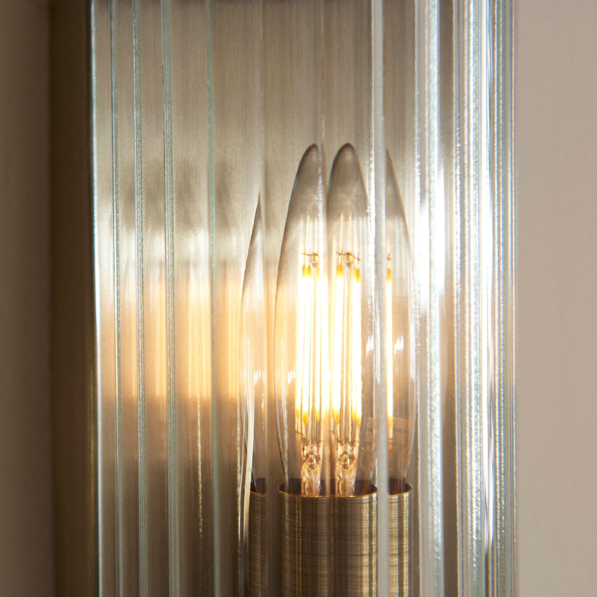 A close-up view of the textured fluted glass and the illuminated bulb within the wall light.