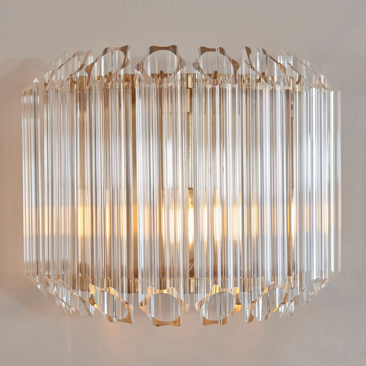 A stylish wall light featuring clear crystal rods in an oval shape, emitting a soft, inviting light.