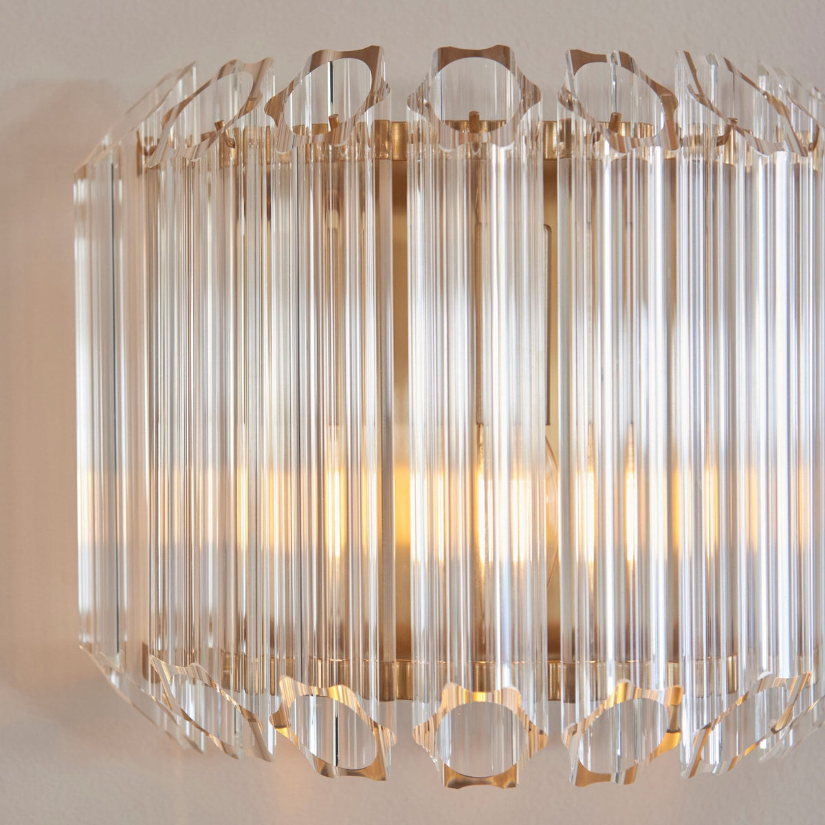 An elegant crystal wall sconce, featuring clear, elongated crystals arranged around a light source, creating a sophisticated look.