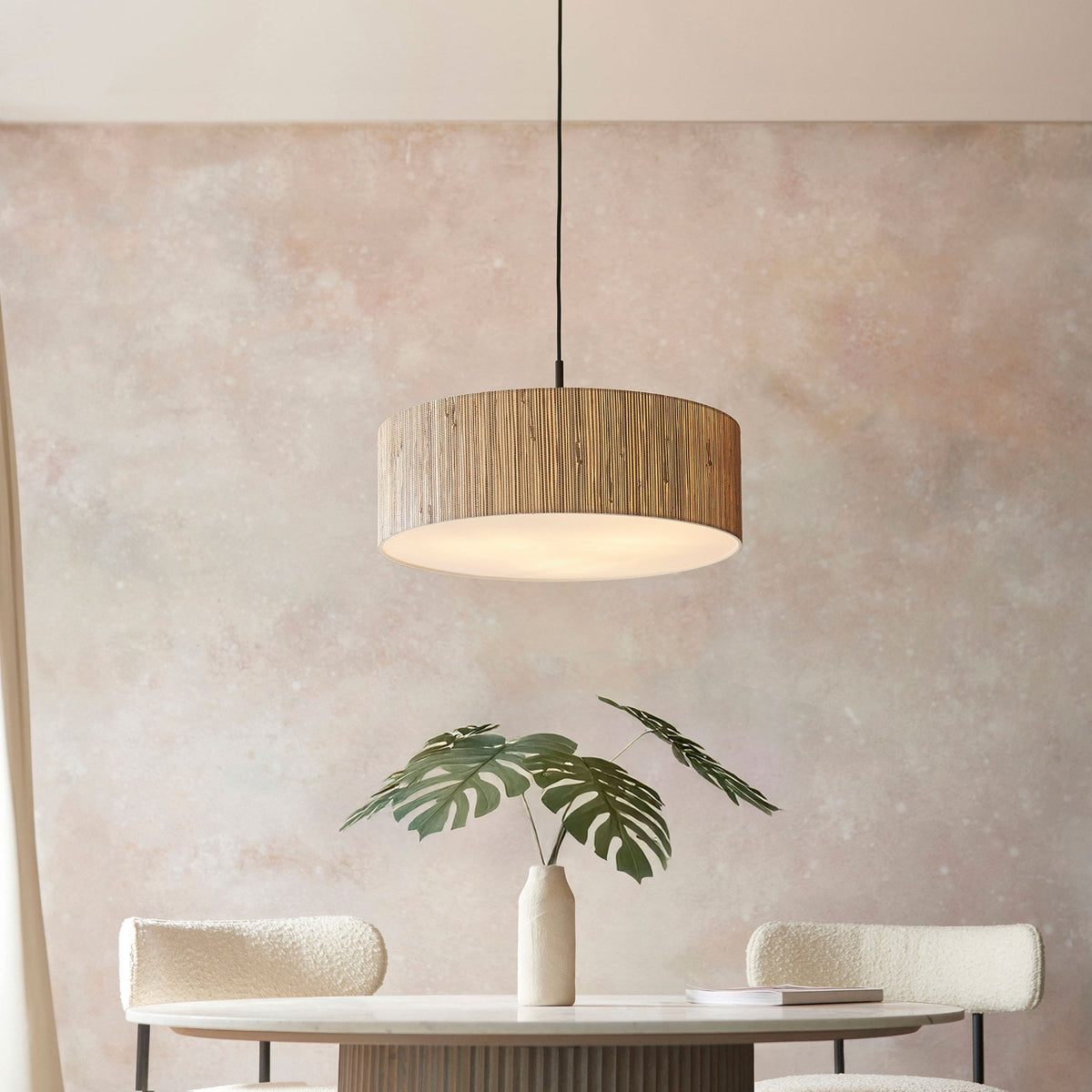 A shot of the pendant light in a dining room, emphasizing its natural texture against a neutral wall.