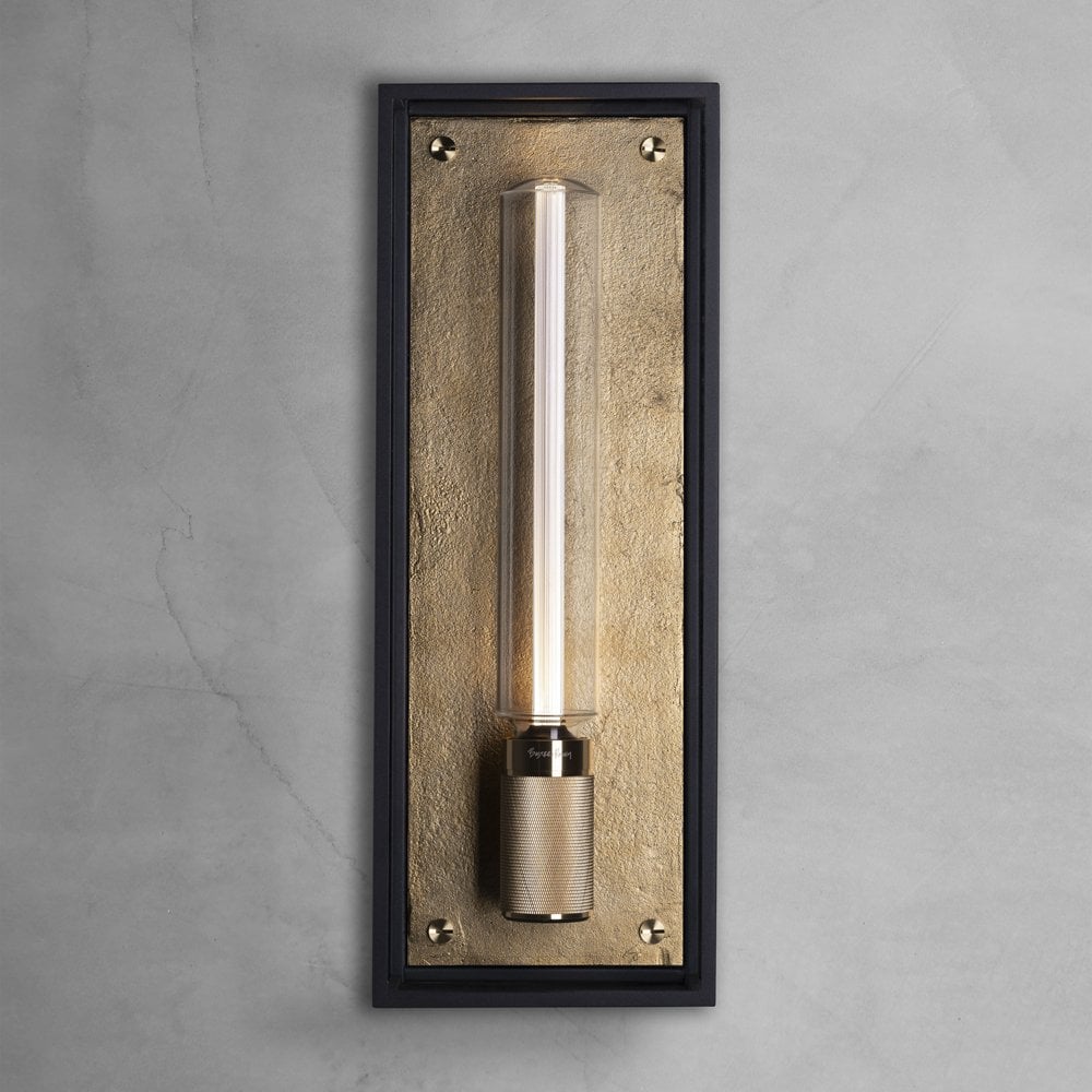 A rectangular wall sconce with a black frame and a gold textured backplate, holding a clear tubular bulb