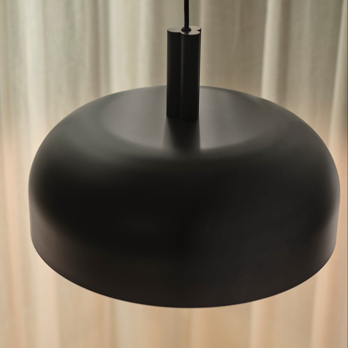 Black metal pendant light with a wide, shallow dome shade