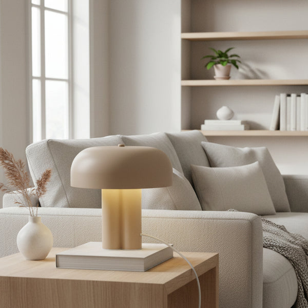 Beige table lamp on a book, on a wooden side table next to a light grey sofa