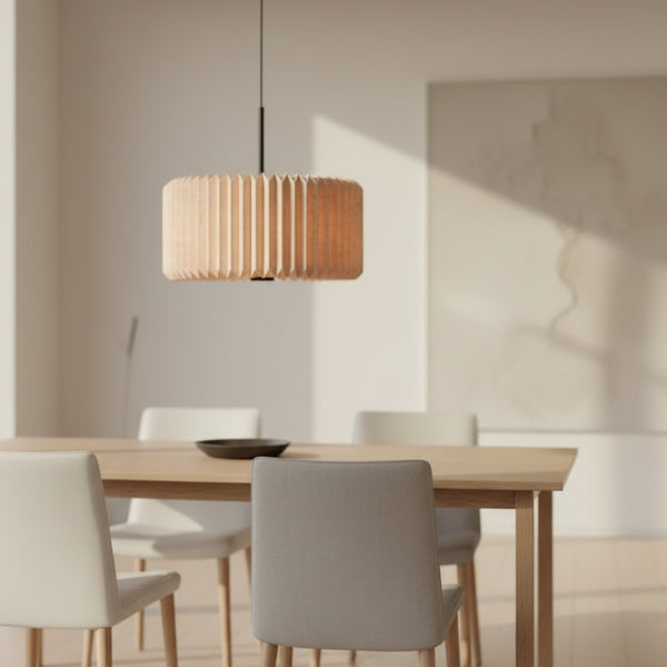 A wooden dining table with four chairs and a pleated wooden pendant light hanging above