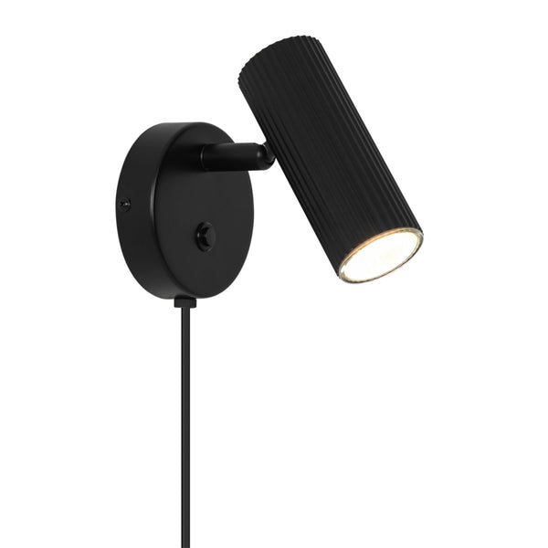 Black wall-mounted spotlight with a ribbed cylindrical shade and a visible power cord