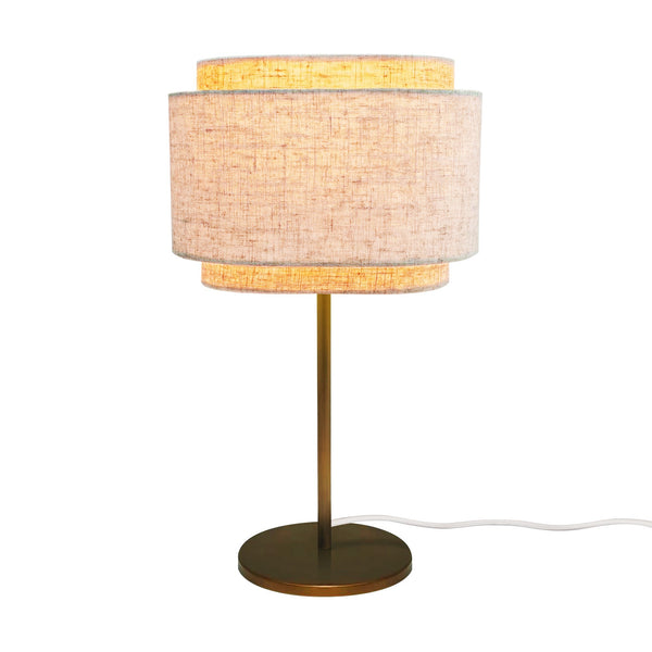 Table lamp with a brass base and stem, and a two-tiered fabric shade in a light beige color