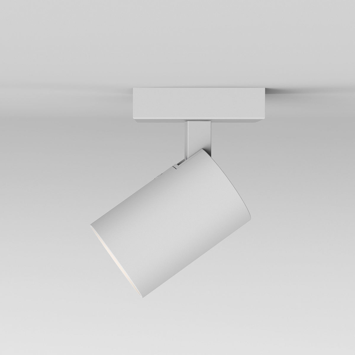 White cylindrical ceiling spotlight with a rectangular base, angled downwards to the left