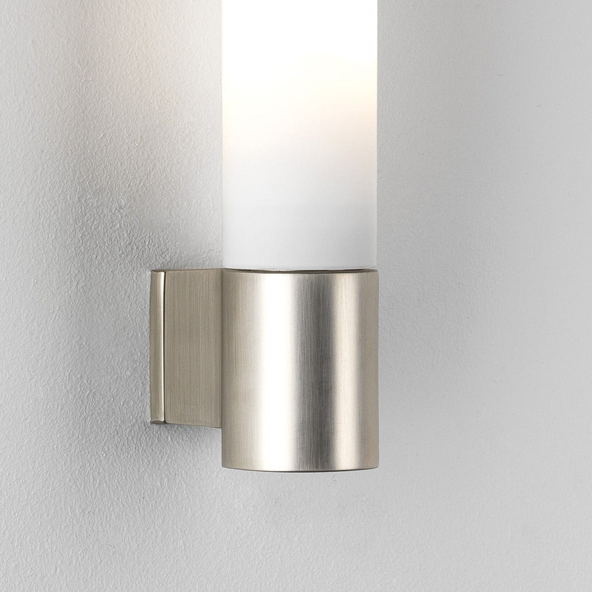Brushed nickel wall sconce with a cylindrical frosted glass shade