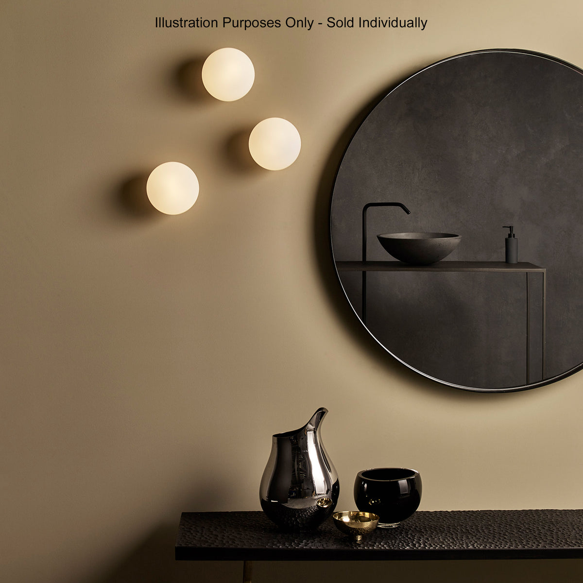 Three round wall lights illuminate a dark bathroom with a circular mirror and black sink