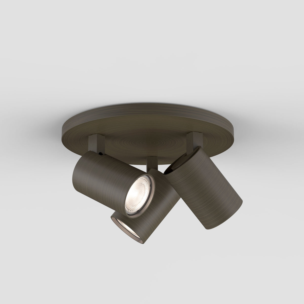 Three dark bronze ceiling spotlights with one light illuminated