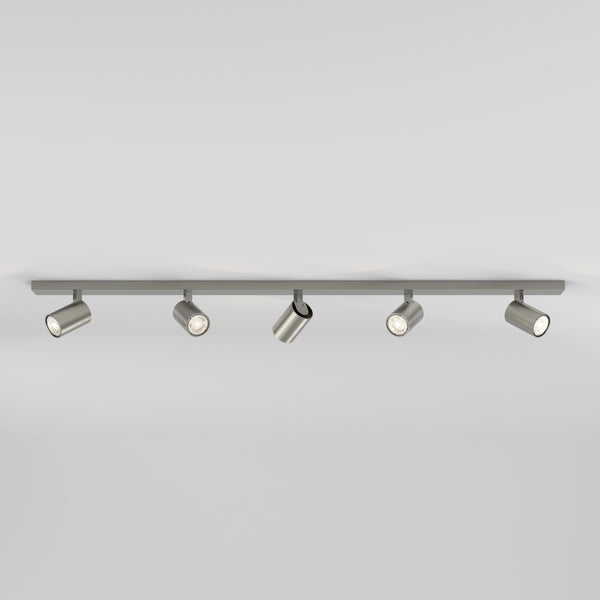 Five brushed metal cylindrical track lights on a grey track against a white ceiling