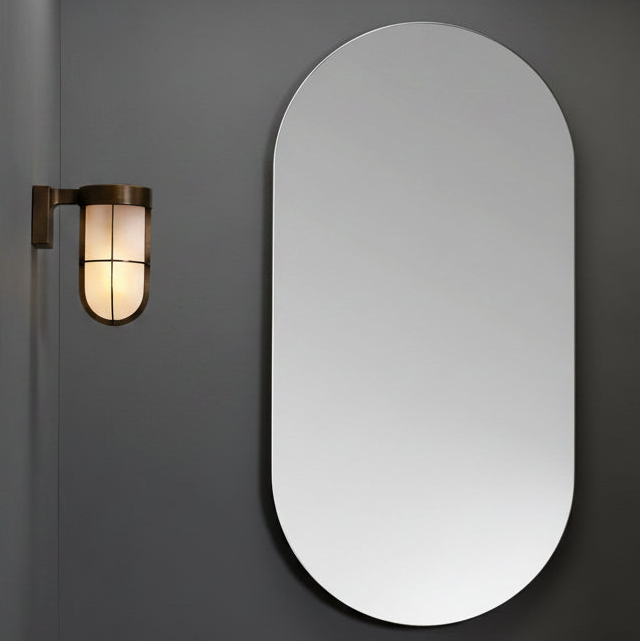Oval mirror and brass wall light