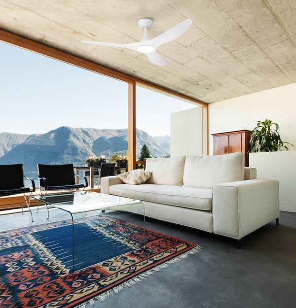 White ceiling fan with light in a modern living room with large windows overlooking mountains