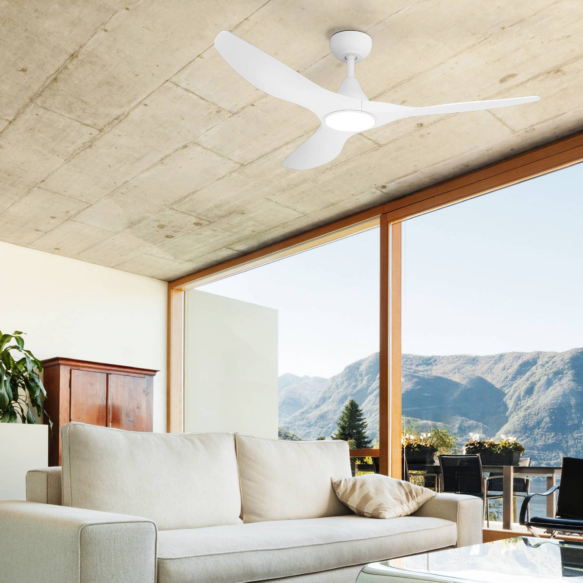 White ceiling fan with three blades and a light in a modern living room with a mountain view