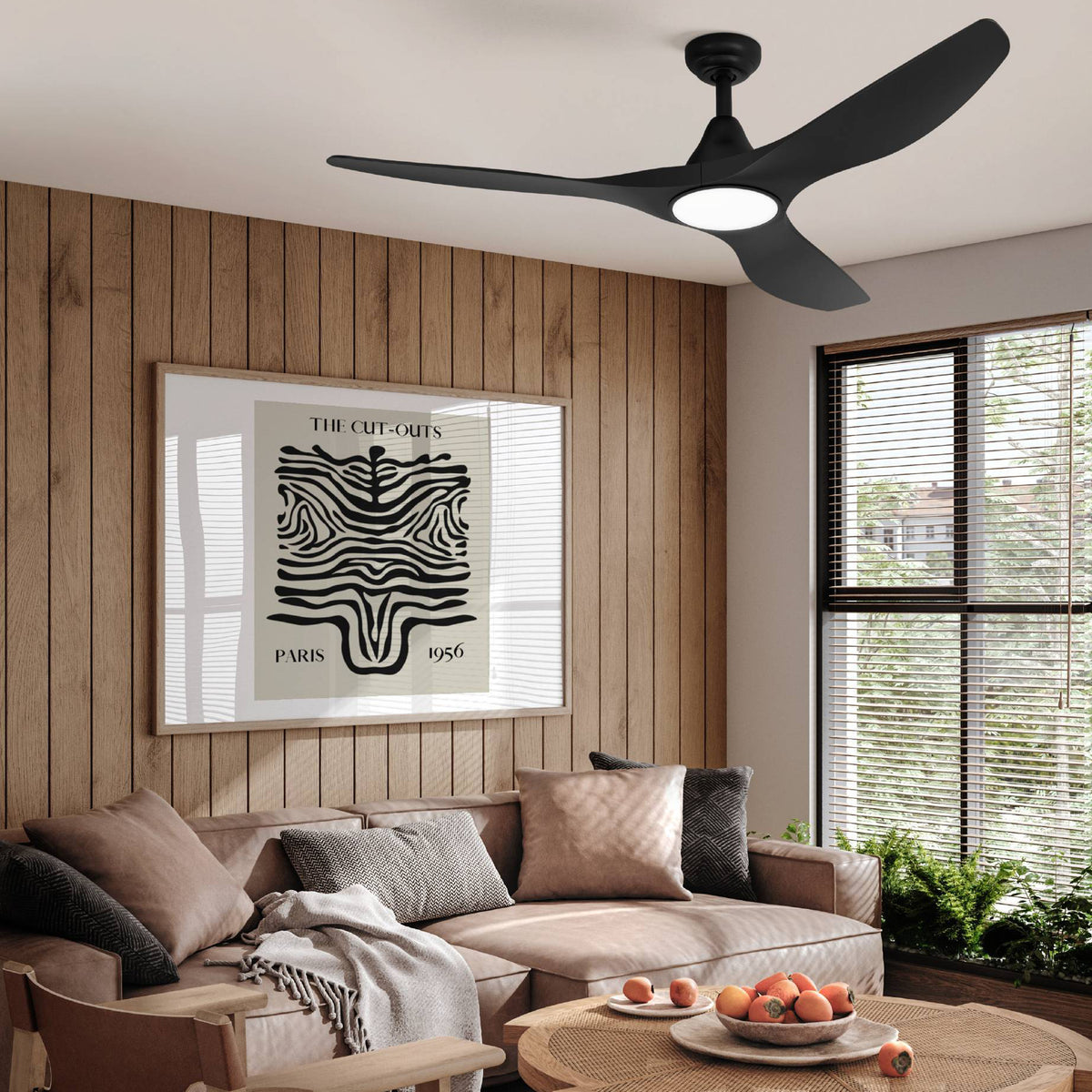 Black ceiling fan with three blades and a central light in a living room with wood paneling