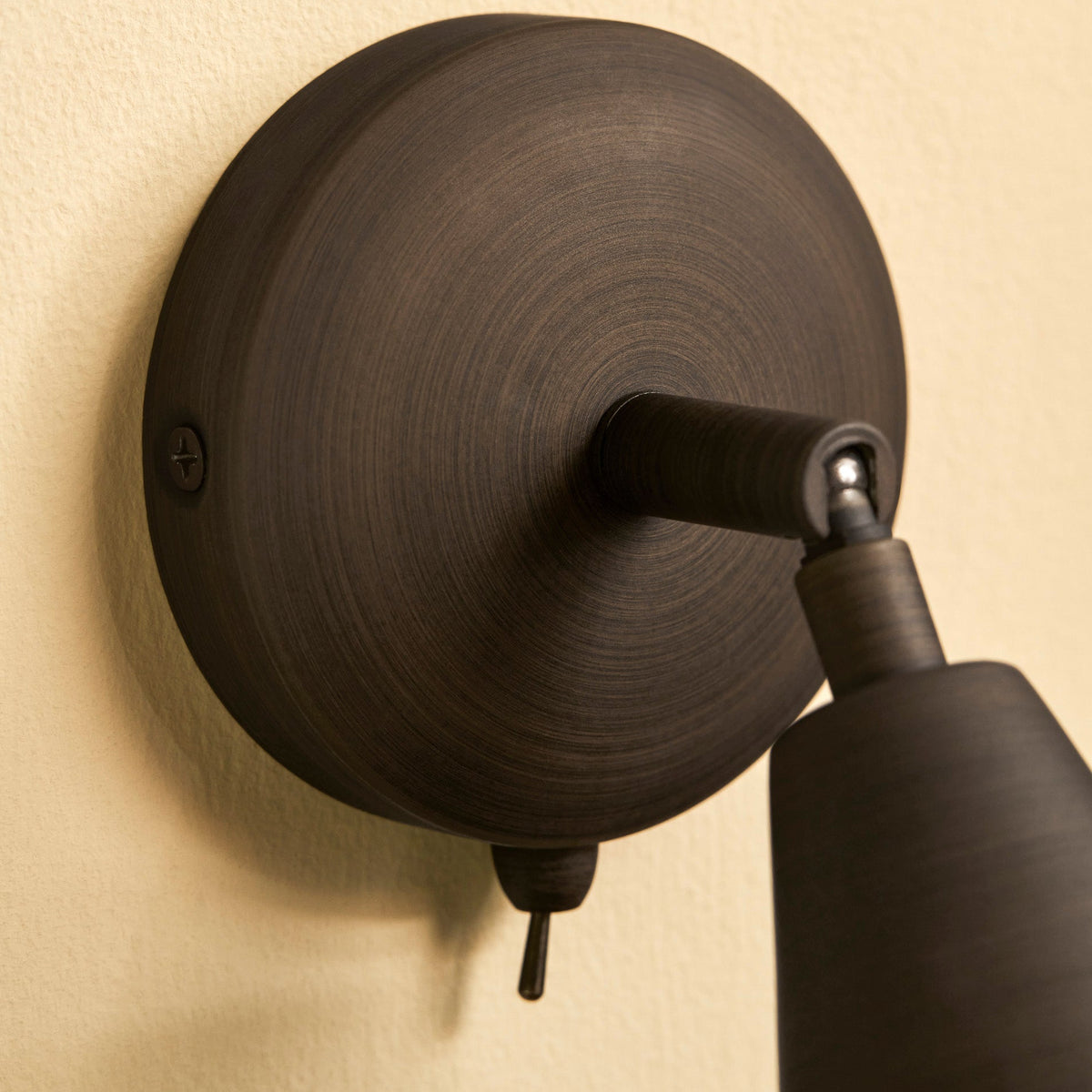 Close up of the antique bronze wall mount and switch for the Garden Trading Alkerton wall spotlight