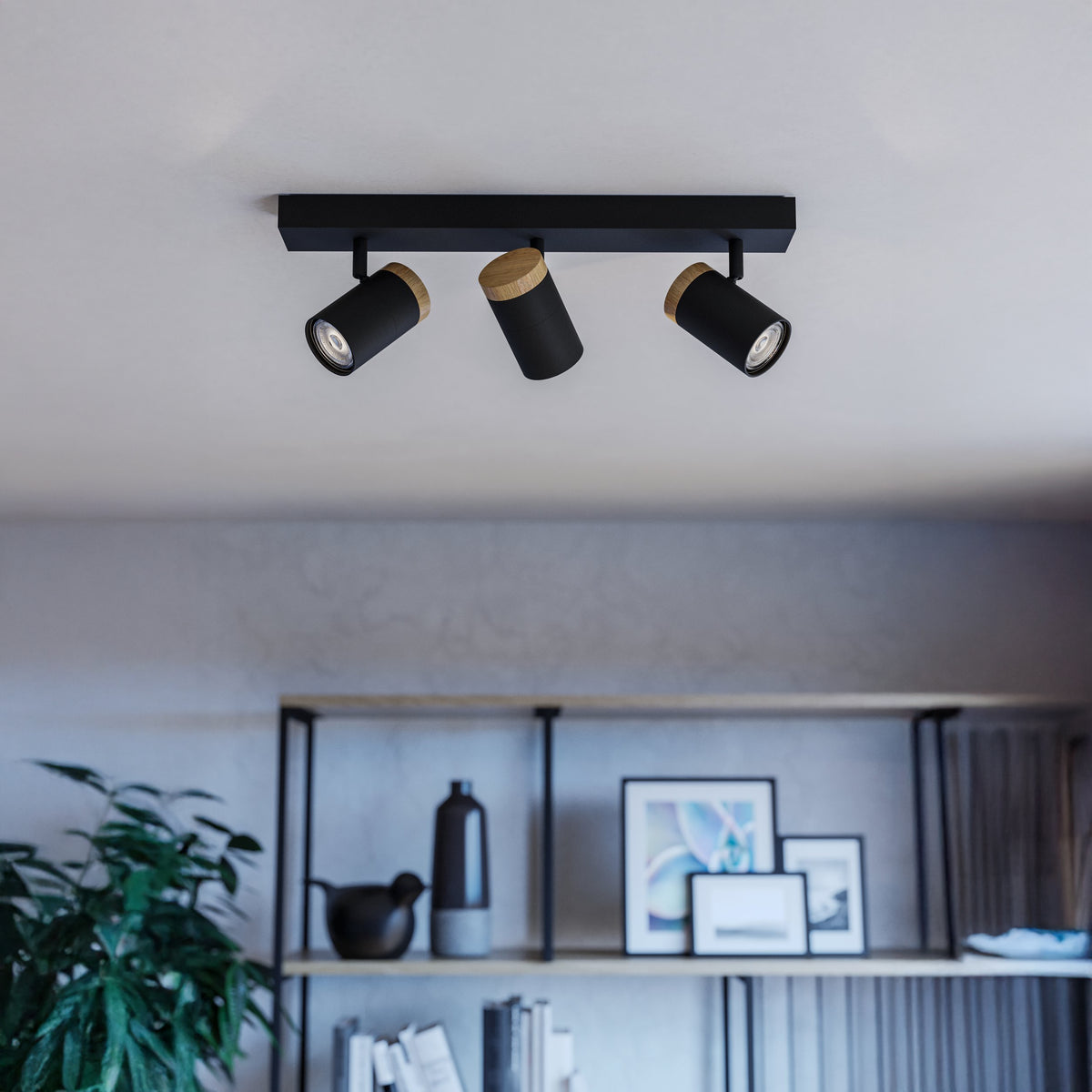 Three black ceiling spotlights with wooden accents illuminate a modern living space.