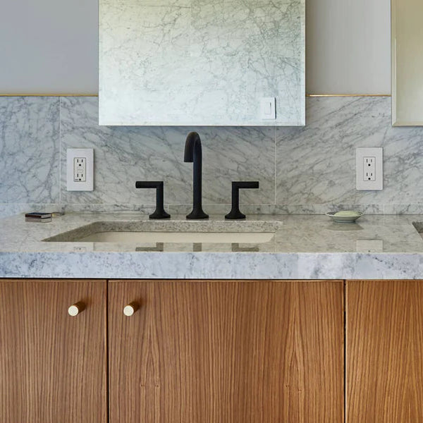 Buster + Punch Knurled Furniture Knob Set in Solid Brass on wooden cabinets under a marble counter