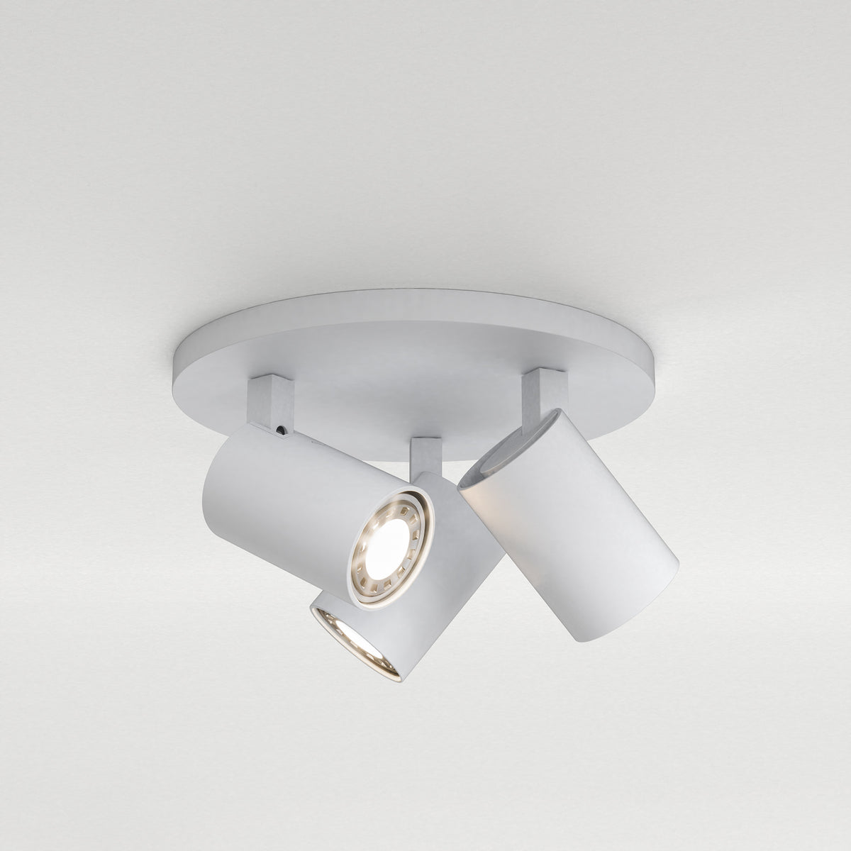 White ceiling light fixture with three adjustable cylindrical spotlights