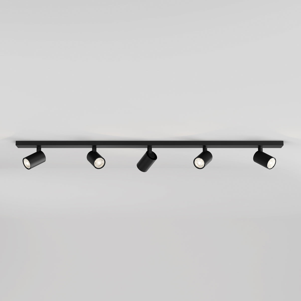Black track lighting fixture with five adjustable cylindrical spotlights