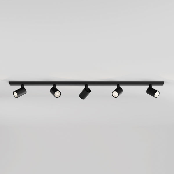 Black track lighting fixture with five adjustable spotlights on a white ceiling
