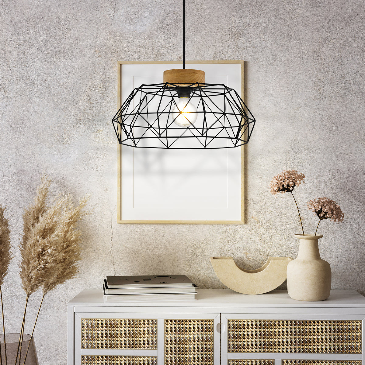 Black geometric pendant light with a wood accent, hanging above a white cabinet with rattan doors