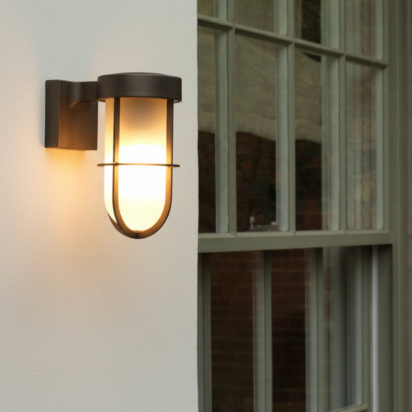 Bronze outdoor wall light with a frosted glass shade and metal cage