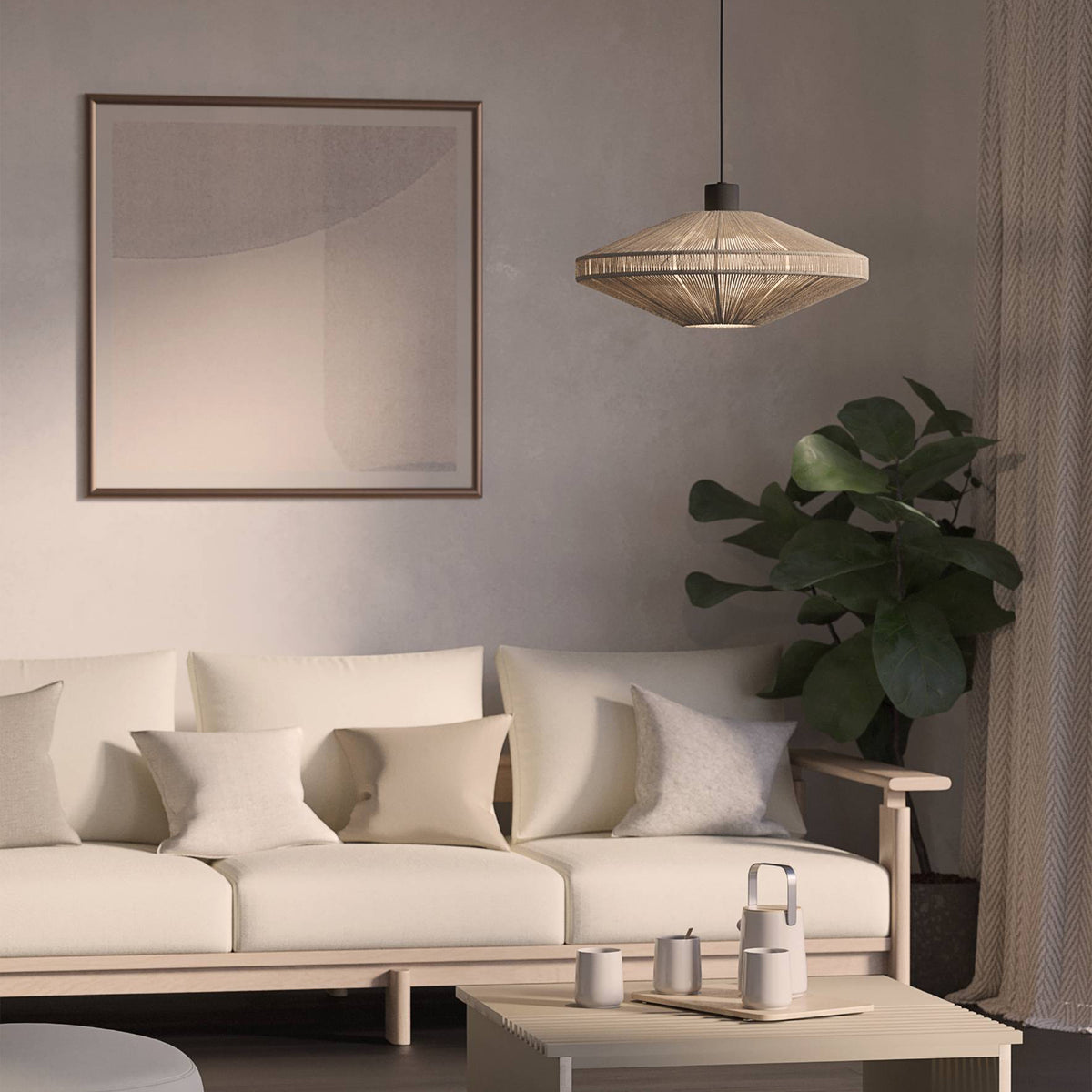 Living room with a light beige sofa, a coffee table with cups, a plant, and a framed picture