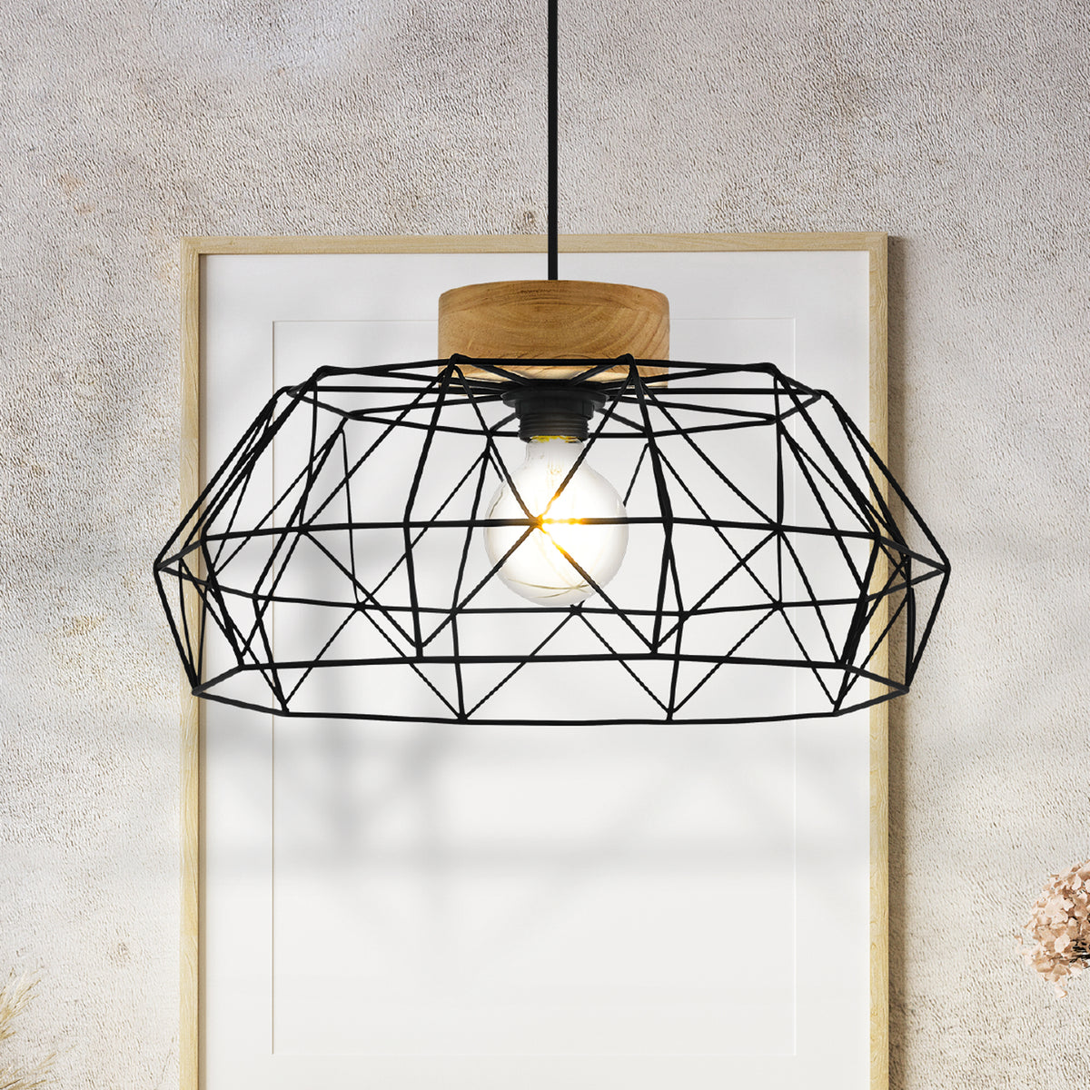 Black geometric pendant light with a wooden top, hanging in front of a white framed picture