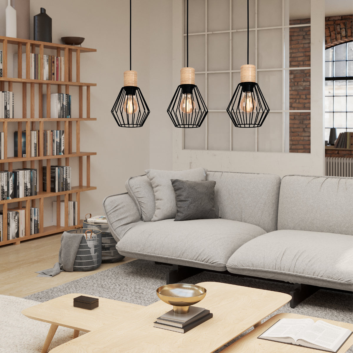 Three black geometric pendant lights with exposed bulbs hang above a light grey sofa and wooden coffee table