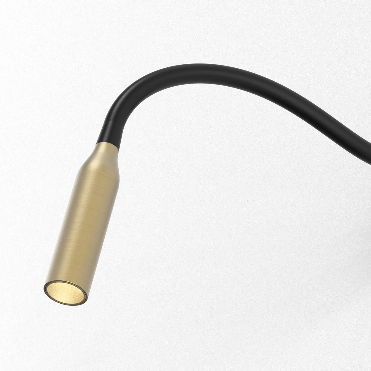 Flexible black and brass wall light with a warm glow