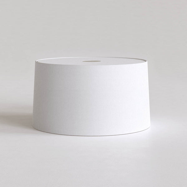 White cylindrical lampshade with a small circular opening at the top