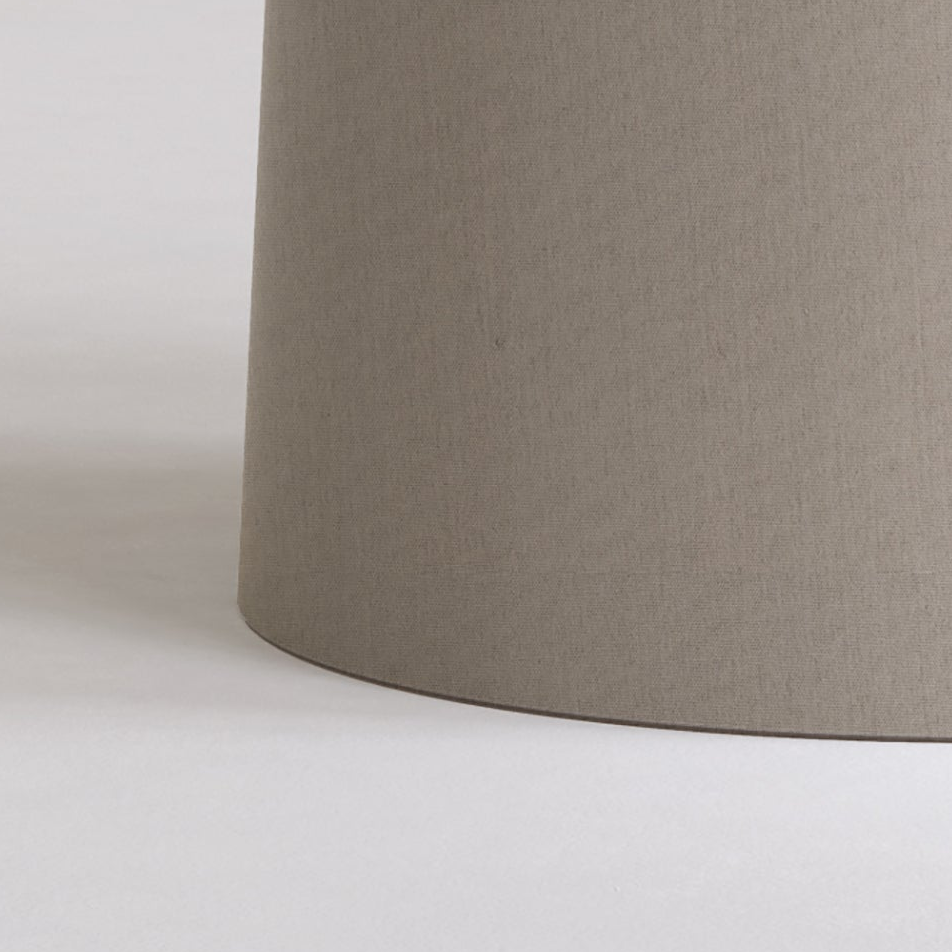 Close up of a cylindrical lampshade in a neutral taupe color