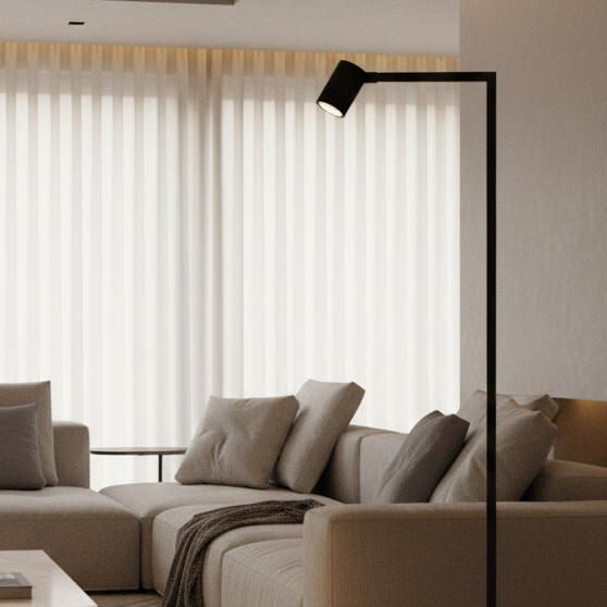 Modern living room with a beige sectional sofa, throw pillows, and a black minimalist floor lamp